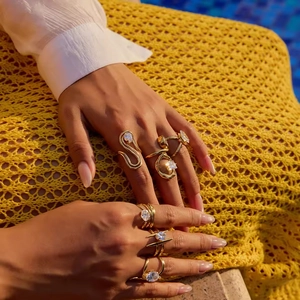 Gold plated stainless steel rings with zircon stones worn by a model in a luxury resort