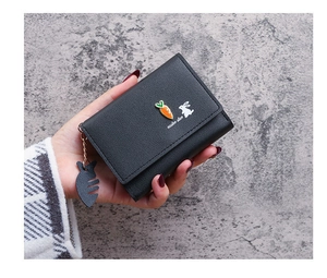 Close-up of black tri-fold faux leather wallet with cute rabbit and fishbone charm