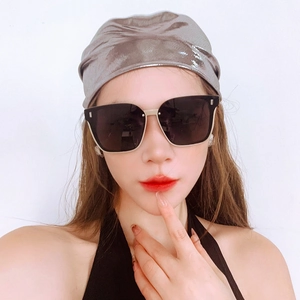 Détail d'un foulard argenté liquide et de lunettes de soleil carrées noires pour un look Y2K