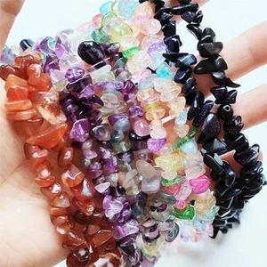 Macro shot of multiple colorful natural crystal stone bracelets held in hand