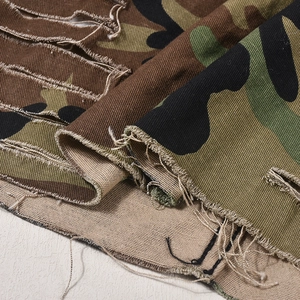 Macro di gonna camouflage in denim con strappi distressed e dettagli sfrangiati