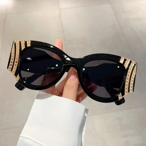 Detail of black thick frame sunglasses with elegant gold striped rhinestone decorations