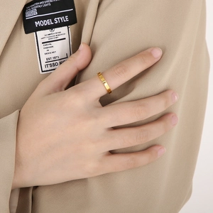 Close-up of 3mm gold stainless steel minimalist flat ring worn by a professional model