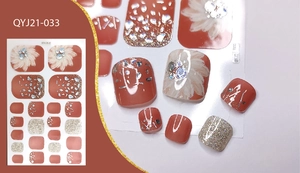 Detail view of red-brown floral toe nail stickers with silver glitter and rhinestone accents