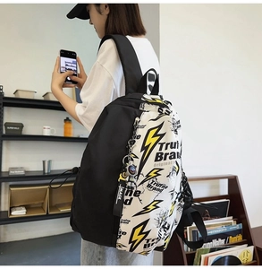 Detailed side view of black and white backpack featuring yellow lightning bolt prints