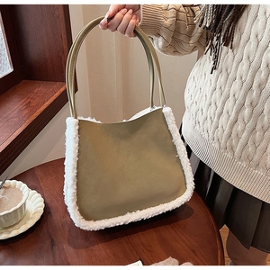Detail of green suede tote bag with white faux fur trim in a cozy indoor setting