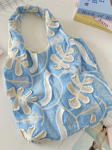 Sac à main bleu ciel à fleurs en dentelle et broderie à franges vue de dessus de 45 degrés