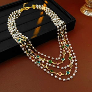 Detail of five-layer vintage pearl necklace with colorful gemstones and gold lobster clasp