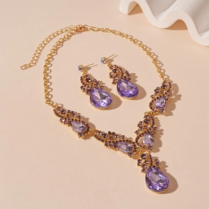 Detail of luxury water drop jewelry set with purple crystals and gold plated finish