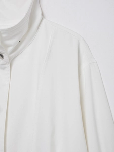 Close-up of white linen jacket stand-up collar and shoulder tailoring details