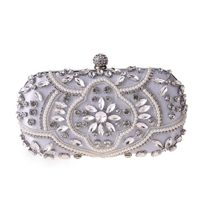 Detail of silver satin clutch with pearl and crystal embroidery and diamond ball clasp