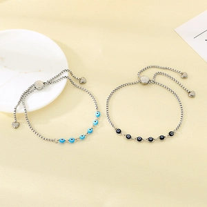 Detail of adjustable silver bolo bracelets with blue and black evil eye resin charms