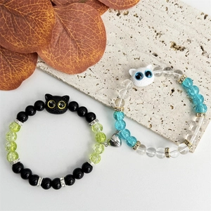 Cute couple beaded bracelets featuring black and white resin cats and magnetic heart charm