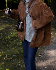 Détail d'une veste en daim marron vintage avec col montant et grandes poches plaquées