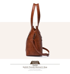Side view of a brown faux leather tote bag with decorative zipper and detachable shoulder strap