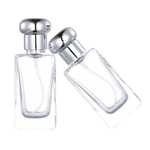 Dettaglio di bottiglie di profumo in vetro da 25ml con tappi argento su sfondo bianco