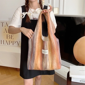Détail d'un sac cabas en laine rayée avec étiquette tissée LOVE SOZAKKA cousue sur le devant