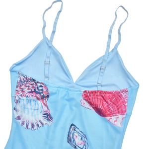Macro shot of seashell print fabric and adjustable strap detail on light blue sundress
