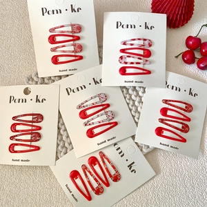 Red floral BB hair clips set with marble patterns and glitter on knit background