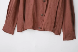 Detailed view of the brown suede fabric texture and button closure of the jacket