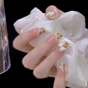 Elegante künstliche Nägel mit Leopardenmuster, weißen Schleifen und Perlendetails