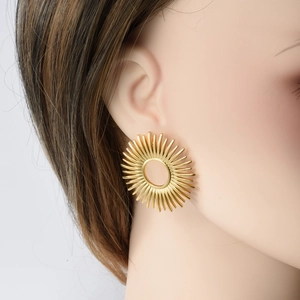 Golden sunburst stud earrings in 304 stainless steel worn by a model in a close-up view