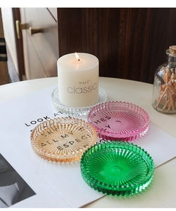 Dettaglio di vassoi per candele in vetro a coste ambra e rosa per decoro domestico