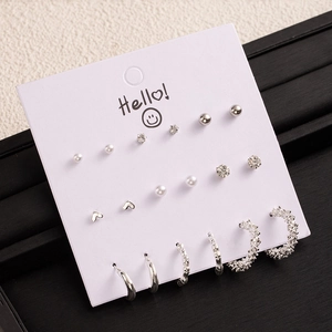 Silver earring set with pearls and studs on white card display