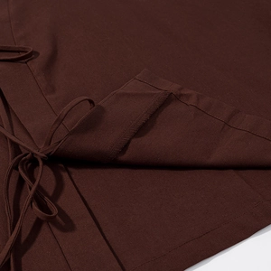 Détail du tissu en coton et lin marron foncé avec coutures et lacets latéraux fins