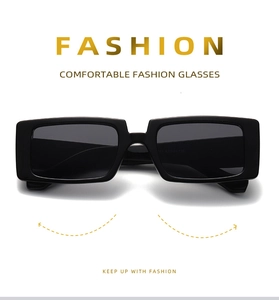 Detail of black rectangular oversized sunglasses with dark lenses on a white background