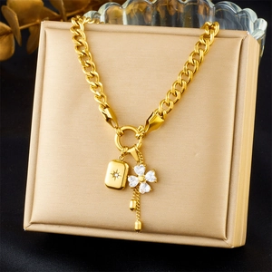 Detail of gold chain necklace with star and diamond clover pendants on jewelry display