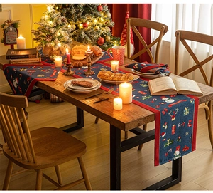 Close-up of festive dark blue Christmas table runner featuring snowman and reindeer patterns