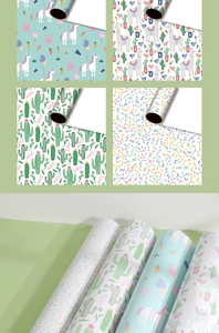Detail view of wrapping paper with cute unicorn, llama, and cactus patterns in rolls