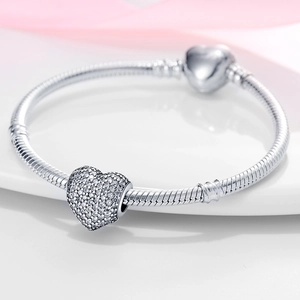 Detail of silver snake chain bracelet with heart charms and sparkling cubic zirconia crystals