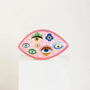 Pink ceramic tray with evil eye, star and moon patterns on a white display pedestal
