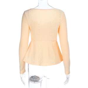 Detailed back view of long sleeve peplum top in orange eyelet fabric with lace texture