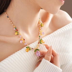 Close-up of golden necklace with colorful teardrop and leaf-shaped zircon crystals