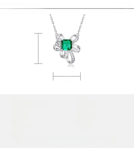 Macro detail of S925 silver bow pendant with emerald cut green stone and size specs