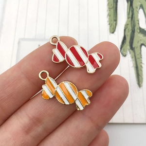 Vue macro de pendentifs en forme de bonbon à rayures rouges et oranges pour bijoux DIY