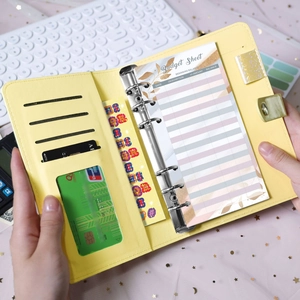 Close-up of yellow PU leather budget binder showing 6-ring binder slots and budget sheets