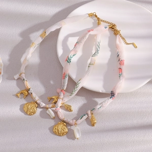 Detail of two layered pink floral fabric necklaces with 18K gold shells and dolphin charms