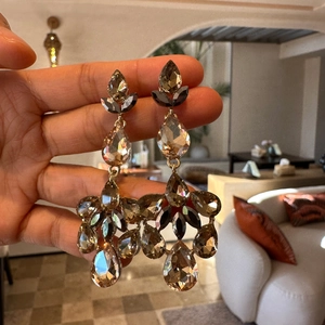 Macro detail of vintage teardrop earrings with amber crystals and bronze tassels