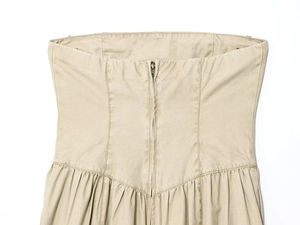Détail de la robe bustier kaki avec fermeture éclair métallique et plis élégants à la taille