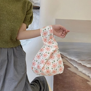 Floral cotton canvas wrist bag detail with pink flower pattern and knotted handle