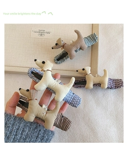 Détail de barrettes à cheveux teckel en peluche avec tissu à carreaux et clochettes rouges