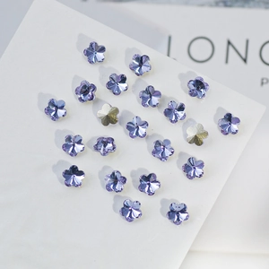 Macro shot of purple flower-shaped K9 crystal rhinestones for nail art and jewelry