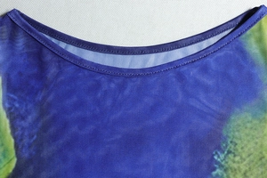 Macro view of the crew neckline and fine stitching on blue-green floral mesh top