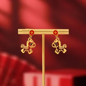 Macro view of 18K gold plated horse pendant earrings with festive red coin studs
