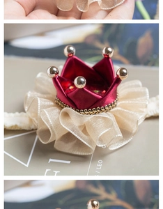 Macro detail of royal red crown hairclip with gold beads and champagne organza lace