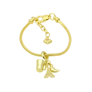 Detailed close-up of 18k gold plated bracelet with Eiffel Tower and croissant charms